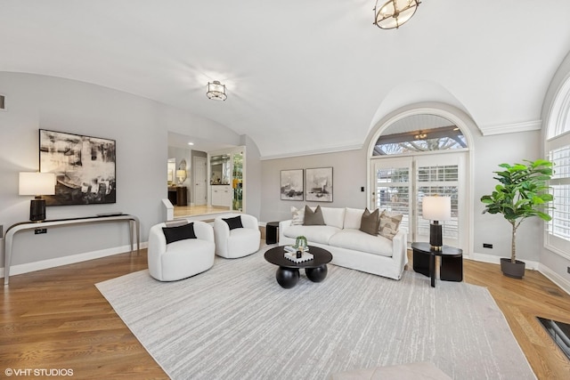 living room with baseboards, wood finished floors, and lofted ceiling