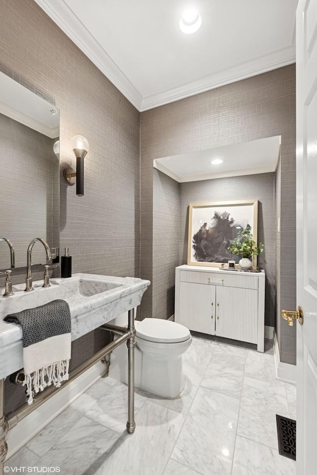 bathroom with vanity, ornamental molding, toilet, and marble finish floor