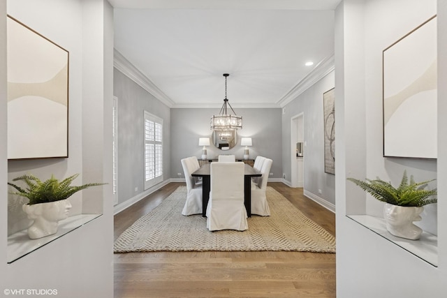 dining room featuring an inviting chandelier, ornamental molding, and light wood finished floors
