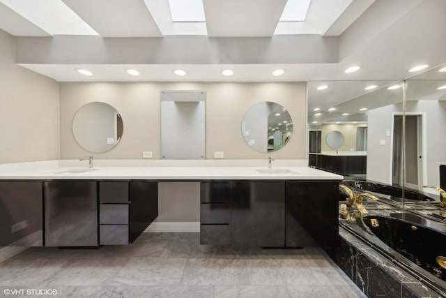 full bathroom with double vanity, a sink, and a skylight