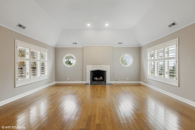 unfurnished living room with visible vents, a wealth of natural light, and a premium fireplace