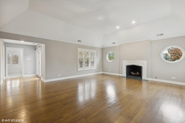 unfurnished living room featuring visible vents, baseboards, and wood finished floors