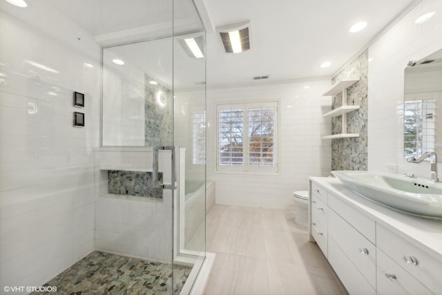 full bathroom featuring tile walls, a stall shower, vanity, tile patterned floors, and toilet