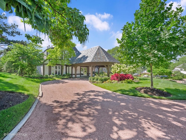 view of community with a yard and driveway