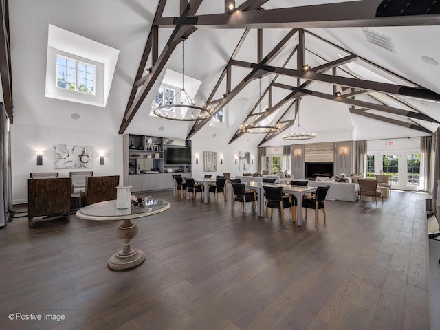 dining area featuring high vaulted ceiling, an inviting chandelier, wood finished floors, and visible vents