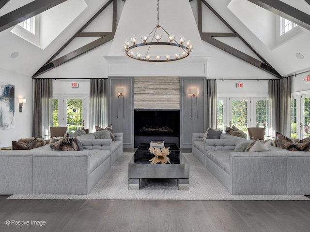 living area with beamed ceiling, high vaulted ceiling, a chandelier, and a skylight