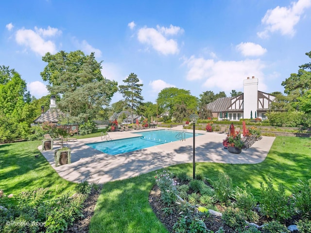 outdoor pool with a yard and a patio area