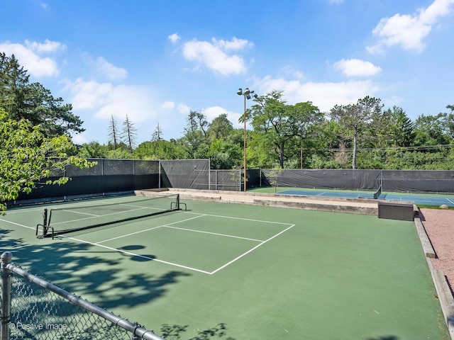view of tennis court featuring fence and community basketball court