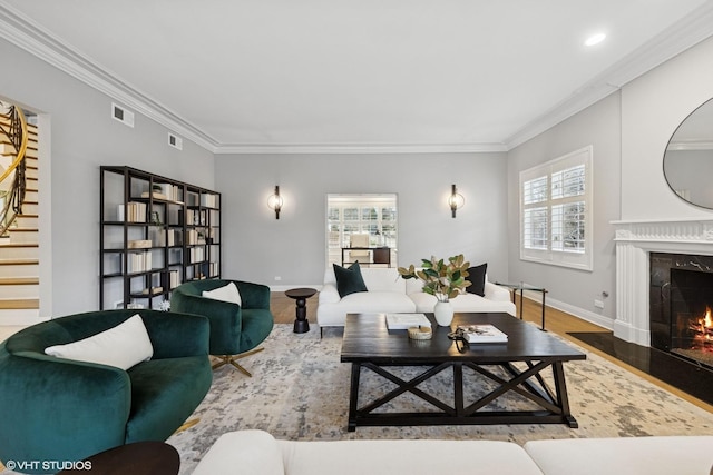 living room with visible vents, ornamental molding, stairs, wood finished floors, and a high end fireplace