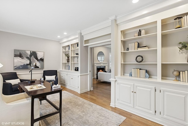 office area with light wood-type flooring, recessed lighting, built in features, and crown molding