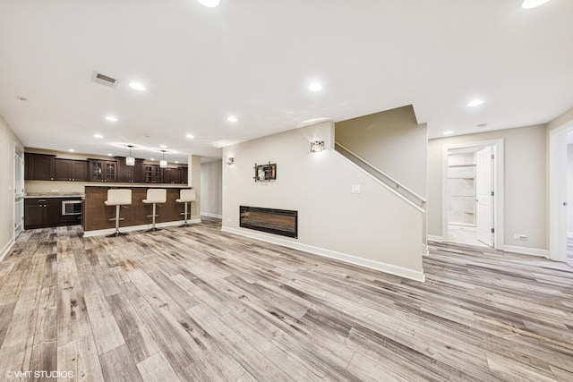 26W241 Arrow Glen Ct, Wheaton, IL 60189 - unfurnished living room with baseboards, light wood-type flooring, recessed lighting, and a glass covered fireplace