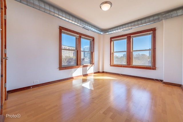 unfurnished room featuring baseboards and light wood-style flooring