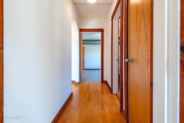 hall with baseboards and light wood-style flooring