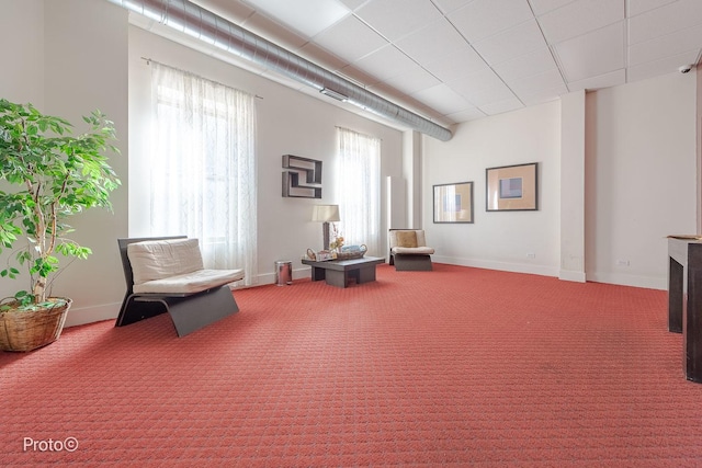 living area featuring baseboards and carpet flooring