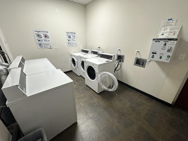 community laundry room featuring separate washer and dryer and baseboards