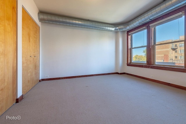 unfurnished room featuring baseboards and carpet