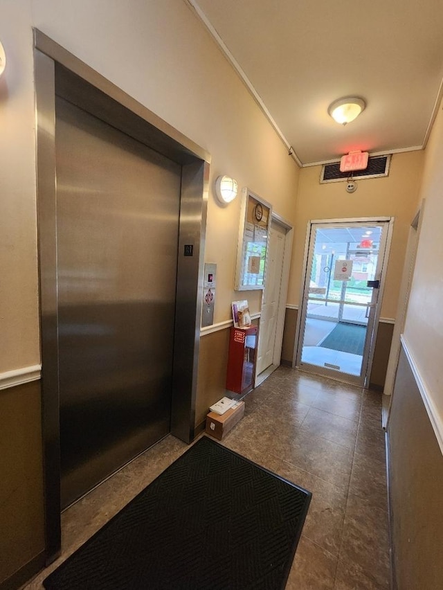 interior space featuring ornamental molding and elevator