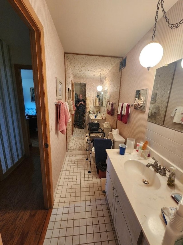 5975 N Odell Ave Unit 2C, Chicago, IL 60631 - bathroom featuring vanity, wood finished floors, and wallpapered walls