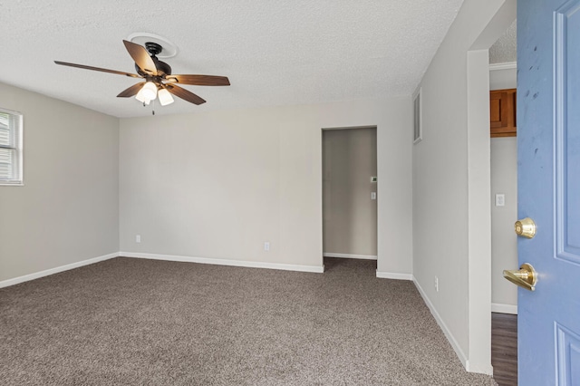 unfurnished room featuring baseboards, a ceiling fan, dark carpet, and a textured ceiling