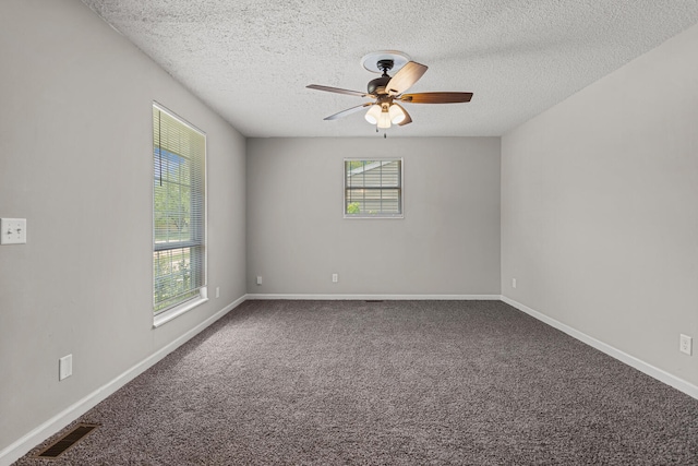 empty room featuring visible vents, a ceiling fan, a textured ceiling, and carpet flooring