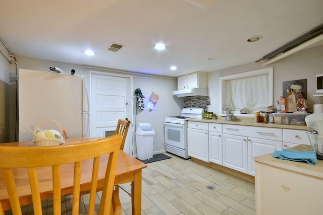 5336 W Nelson St, Chicago, IL 60641 - kitchen featuring visible vents, white appliances, light countertops, white cabinetry, and under cabinet range hood
