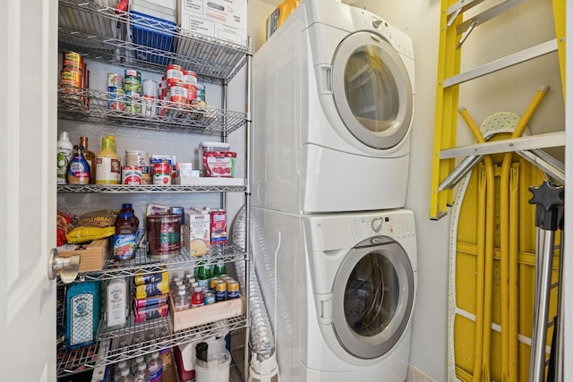 washroom featuring stacked washer / drying machine and laundry area