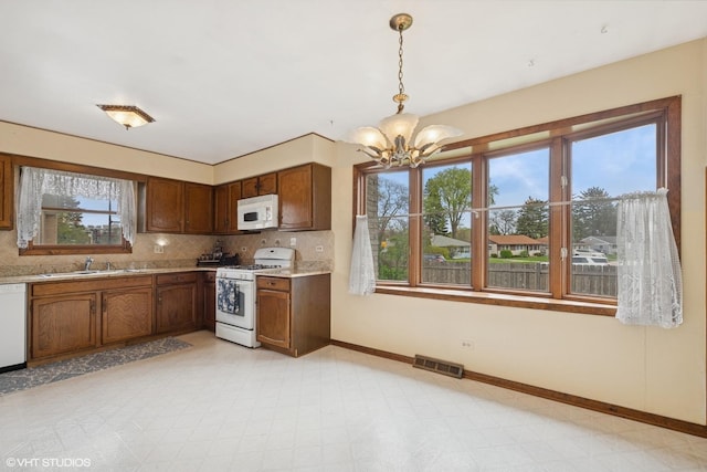 515 S Inner Circle Dr, Mount Prospect, IL 60056 - kitchen with a sink, white appliances, a chandelier, light floors, and visible vents