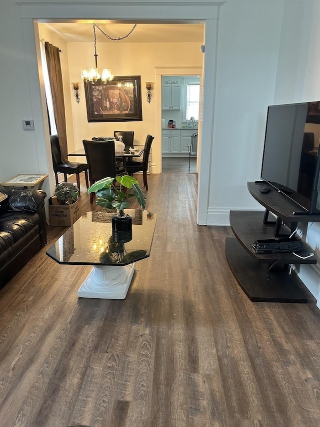 living area featuring dark wood-style floors and a chandelier