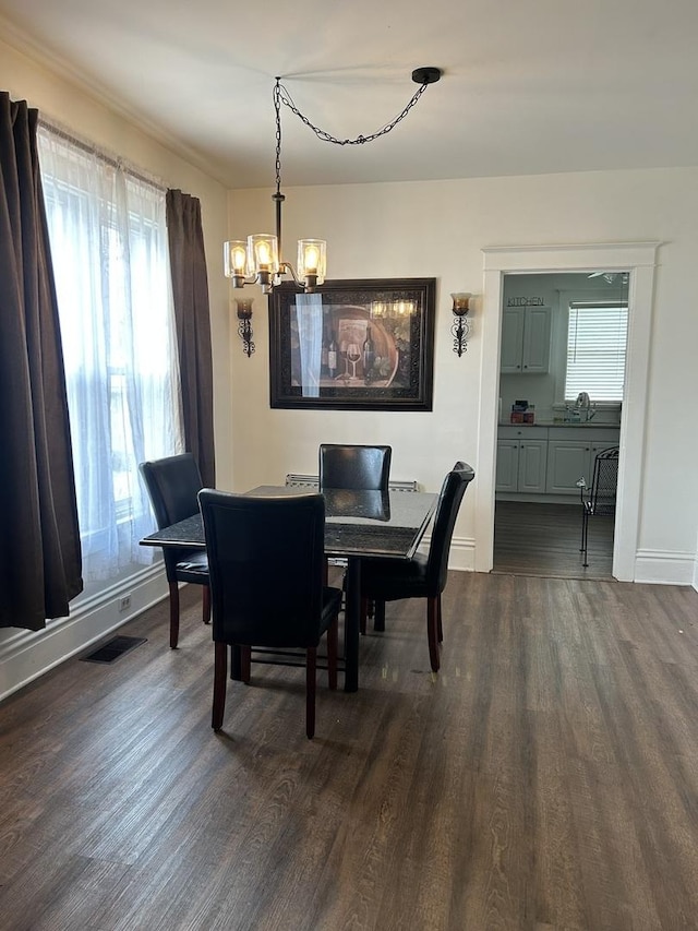 dining space featuring an inviting chandelier, dark wood-type flooring, visible vents, and a healthy amount of sunlight