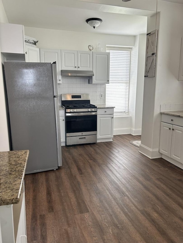 kitchen featuring white cabinets, appliances with stainless steel finishes, tasteful backsplash, under cabinet range hood, and dark wood-type flooring