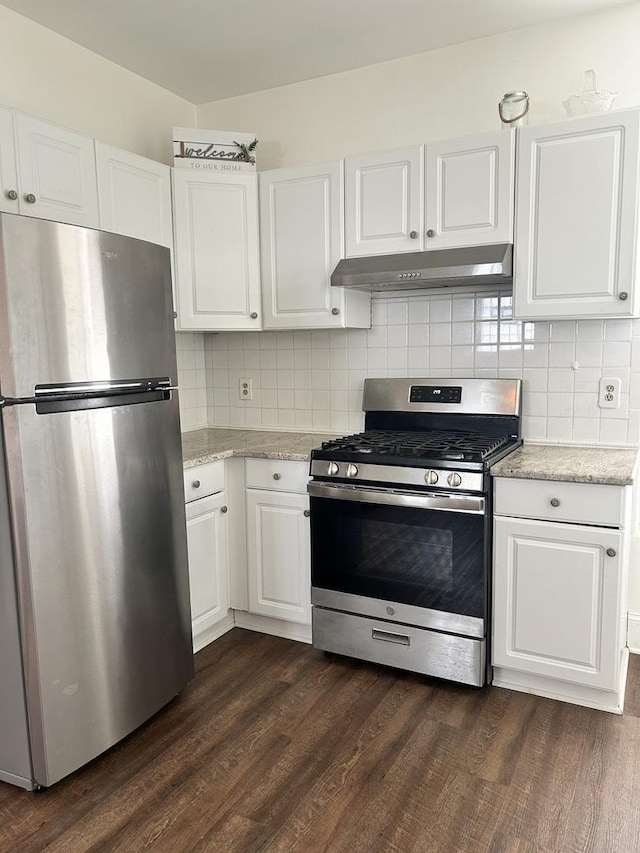 kitchen with under cabinet range hood, stainless steel appliances, white cabinets, and dark wood finished floors