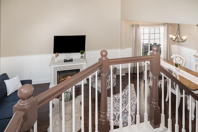 553 Ivory Ln, Bartlett, IL 60103 - stairs with a wainscoted wall, a lit fireplace, a decorative wall, and a notable chandelier