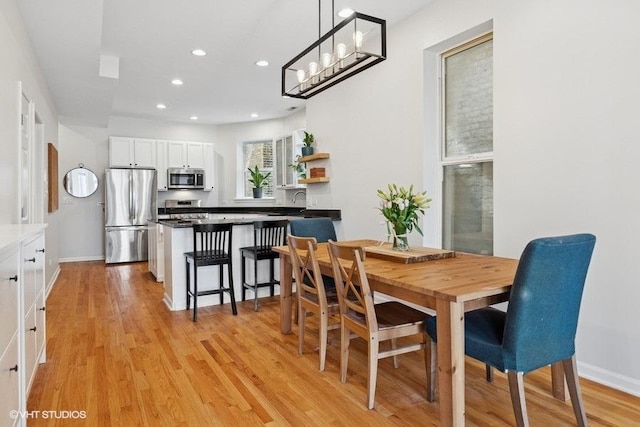 dining area with recessed lighting, baseboards, a notable chandelier, and light wood-type flooring