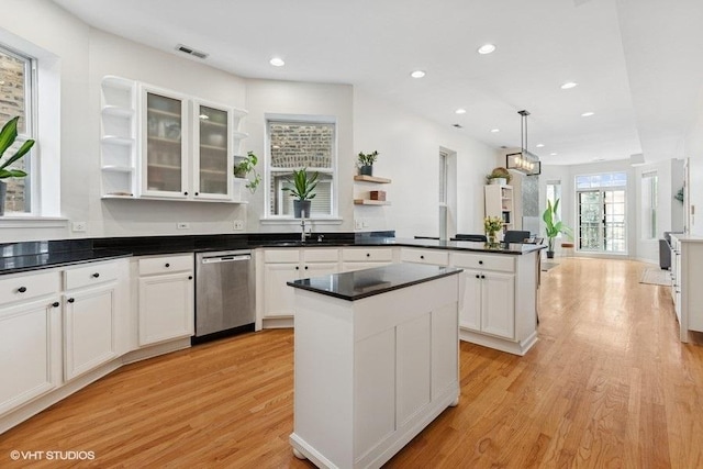 kitchen with open shelves, light wood finished floors, dishwasher, a peninsula, and visible vents