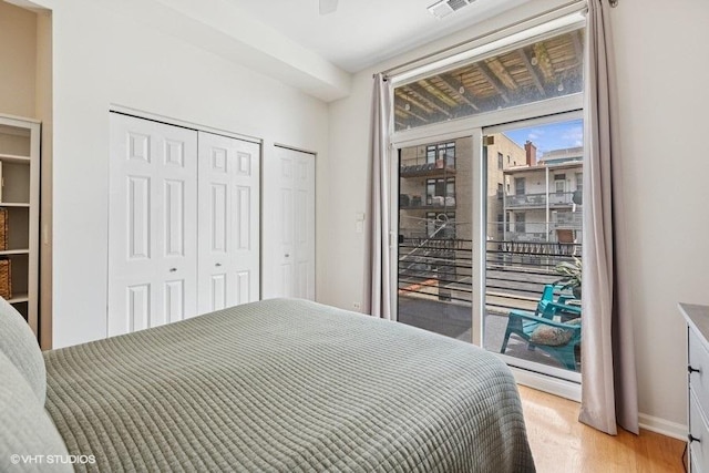 bedroom featuring access to outside, baseboards, visible vents, and light wood-type flooring