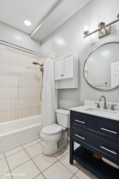 bathroom with toilet, shower / bath combo, tile patterned flooring, and vanity