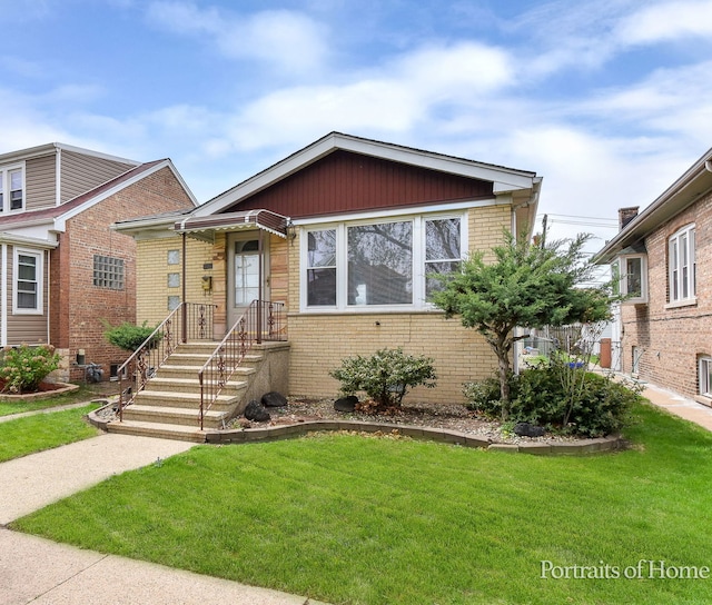 bungalow-style house featuring brick siding and a front lawn