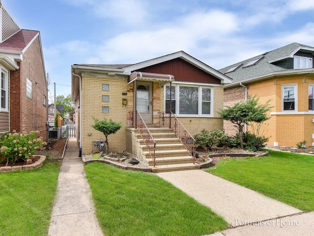 bungalow-style home with entry steps, a front yard, and brick siding