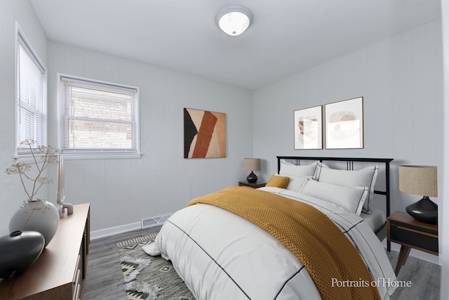 bedroom featuring baseboards, wood finished floors, and visible vents