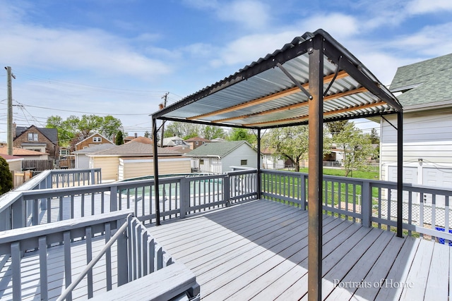 wooden terrace featuring fence, a residential view, and an outdoor structure