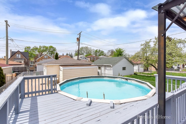 view of pool with a deck, fence, an outbuilding, and a fenced in pool