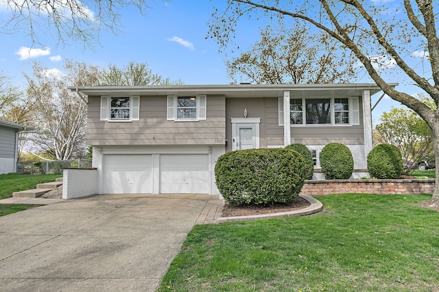 bi-level home featuring brick siding, a garage, a front lawn, and concrete driveway