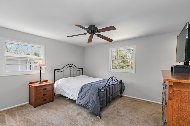 bedroom featuring baseboards, multiple windows, and light carpet