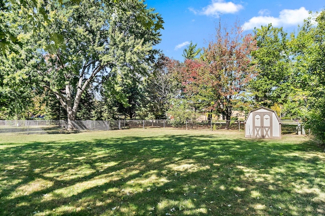 view of yard featuring an outdoor structure, a fenced backyard, and a shed