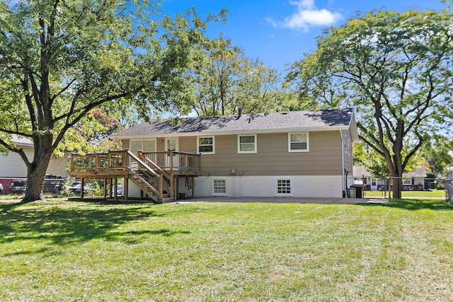 back of property featuring fence, a deck, a lawn, and stairway