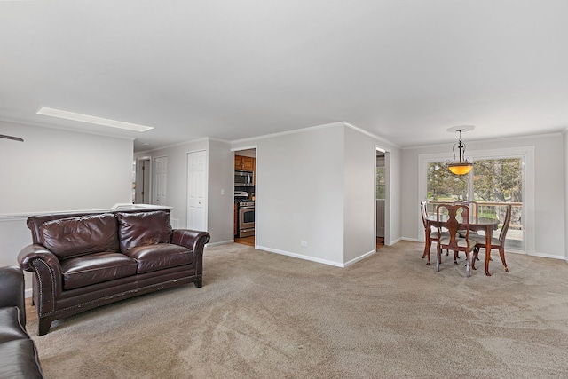living room with baseboards, ornamental molding, and light carpet