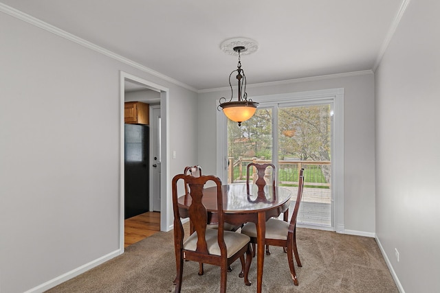 carpeted dining room with baseboards and ornamental molding