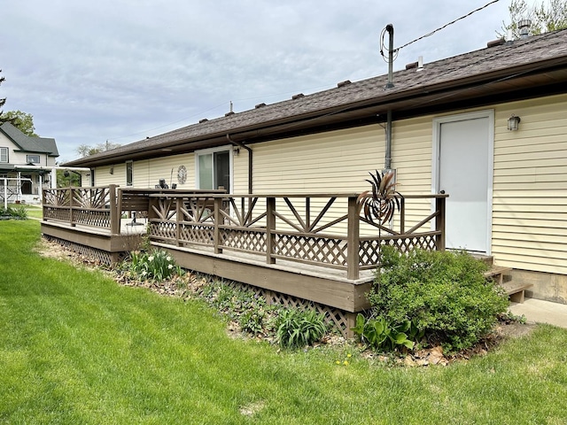 rear view of house featuring a lawn and a wooden deck
