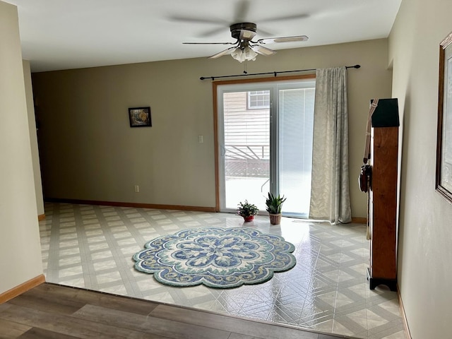 unfurnished room with ceiling fan, baseboards, and light floors