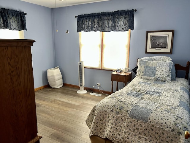 bedroom featuring baseboards and wood finished floors
